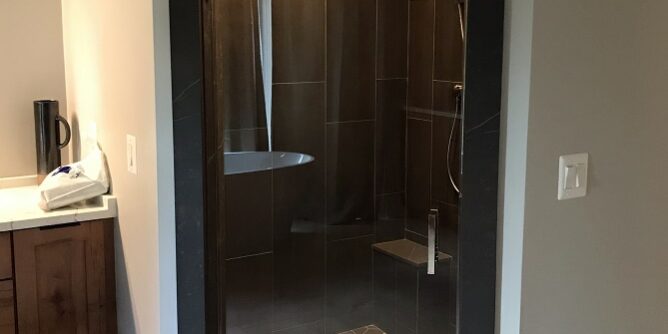 Swing glass door to wet room shower enclosure