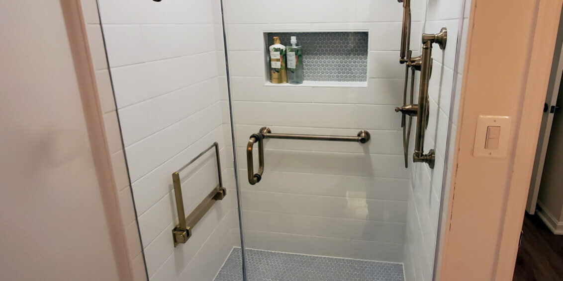 Shower door with custom brushed bronze hardware