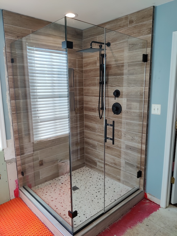 modern frameless glass corner shower door installation in Brunswick, MD - matte black with ladder pull handle